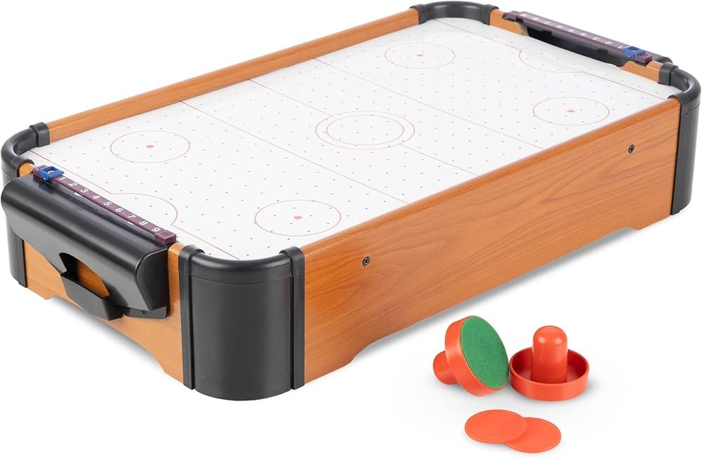 Battery operated mini air hockey table with mallets and pucks in a living room