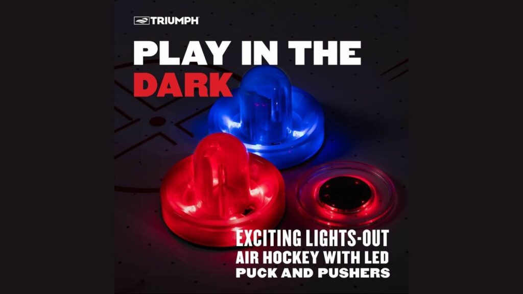 Glowing air hockey puck resting on a white air hockey table in a dim room