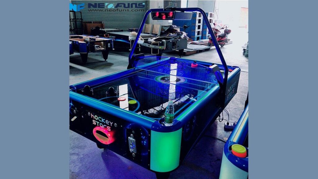 Red and blue air hockey pushers resting on a polished air hockey table